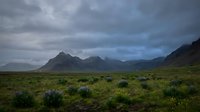 Dramatic mountain landscape with moody storm clouds over vast green valley and wildflower meadow, suitable for nature, travel, and environmental design projects.