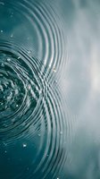 Concentric water ripples creating mesmerizing circular patterns on calm turquoise surface with gentle reflections and natural light effects.