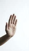 Male hand raised in stop gesture against white background isolated for design and communication concepts.