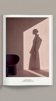 Woman in long coat standing in minimalist interior with dramatic shadow cast on wall, sunlight streaming through window, modern architectural space with purple chair, contemporary fashion and lifestyle concept.