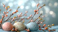 Speckled Easter eggs in pastel colors with spring pussy willow branches against soft bokeh background create festive holiday atmosphere.