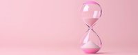 Pink hourglass with flowing sand on soft pink background symbolizing time management, deadlines, and productivity concepts for business presentations.