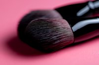 Soft makeup brush bristles in macro view against pink background, showing professional cosmetic tool texture and detail for beauty and cosmetics industry.