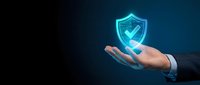 Businessman hand holding glowing cybersecurity shield with checkmark on dark blue background for digital protection and data security concepts.