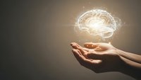 Glowing brain hologram floating above open hands representing artificial intelligence, mental health, neuroscience and innovative thinking concepts.