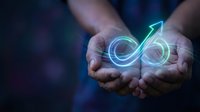 Hands holding glowing infinity symbol with neon light effect representing endless possibilities, sustainable business growth and unlimited potential.