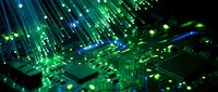 Green illuminated circuit board with glowing fiber optic cables and LED lights creating futuristic technology background for digital innovation concepts.