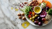 Mediterranean diet platter with fresh vegetables, nuts, olive oil and healthy ingredients on marble background for nutritious meal planning.
