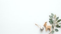 Isolated wooden deer figurine with metal bell ornament and dried eucalyptus branches on white background, ready for holiday design, greeting cards, and seasonal decorations.