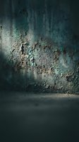 Weathered concrete wall with peeling paint and rust stains showing age and decay in moody atmospheric lighting for industrial design projects.