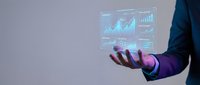 Businessman in dark suit holding holographic data analytics dashboard with glowing charts and graphs for business intelligence, financial reporting, and digital transformation projects.