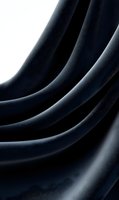 Elegant dark fabric waves creating smooth curves and shadows against black background, abstract minimalist composition for luxury design projects and presentations.