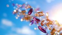 Flying vitamin and supplement capsules with omega-3 and fish oil on blue sky background with bokeh lights and sunbeams, healthcare concept.