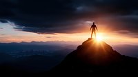 Silhouette of person standing on mountain peak at sunset with dramatic sky and city lights below. Achievement success motivation concept for business leadership.