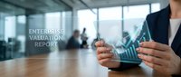 Professional businesswoman analyzing enterprise valuation report with digital financial charts and growth graphs in modern corporate office environment.