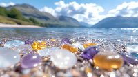Colorful healing crystals and gemstones on beach shore with mountain lake and peaks in background, selective focus on stones creates dreamy atmosphere.