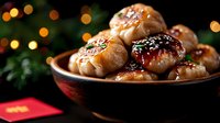 Glazed Asian dumplings with sesame seeds served in wooden bowl against festive bokeh lights background, traditional lunar new year celebration food.