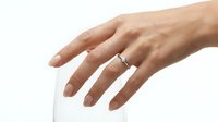 Close-up of a woman's hand wearing a silver band ring, displayed on white background for jewelry marketing and wedding ring advertising purposes.