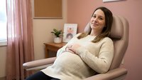 Pregnant woman relaxing in comfortable chair at home, expecting mother in cozy living room setting, maternity lifestyle and wellness concept.