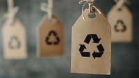 Eco-friendly cardboard tags with recycling symbols hanging on string, sustainable packaging labels for environmentally conscious branding and green marketing campaigns.