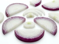 Fresh red onion slices cut into rings and segments on white background, isolated vegetable ingredient for cooking and culinary preparations.
