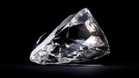 Clear raw diamond crystal with sharp facets and natural formations against dark background, showcasing brilliance and light refraction in luxury mineral specimen.