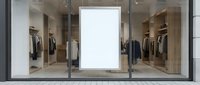 Modern clothing store front with blank white poster frame in window display for advertising mockup. Contemporary retail fashion boutique exterior showcase.