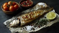 Grilled whole mackerel on parchment paper with fresh lime, sea salt, peppercorns, rosemary sprigs and cherry tomatoes against dark background, food photography.