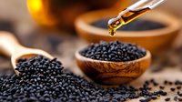 Black cumin seeds in wooden spoon with essential oil dropping from glass pipette, natural healing ingredients on rustic background, wellness concept.