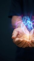 Human hands holding glowing holographic heart with blue and pink light effects on dark background for medical healthcare technology concepts.