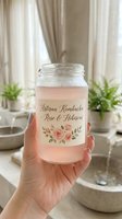 Hand holding artisan kombucha jar with rose hibiscus flavor in bright kitchen setting with plants and natural lighting for healthy lifestyle branding.