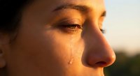 Young woman with closed eyes in warm golden sunlight creating natural glow on face during sunset hour for wellness and mindfulness concepts.