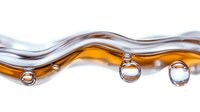 Abstract liquid waves in amber and silver tones with floating droplets creating dynamic fluid motion for modern design projects.