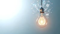Glowing light bulb with business icons and data analytics symbols representing innovation, creativity and strategic planning for corporate growth.