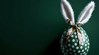Festive Easter egg with bunny ears decoration against dark green background. Creative holiday concept for spring celebrations.