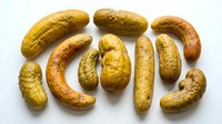 Assorted pickled cucumbers and gherkins arranged on white background, ready for food packaging, recipe blogs, culinary websites and restaurant menus.