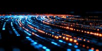 Abstract digital light trails in blue and orange colors creating dynamic curved lines against dark background, representing data flow and technology advancement.