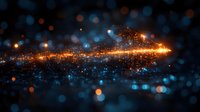 Glowing orange and blue particles with light streaks create magical atmosphere against dark background. Abstract bokeh effect shows motion and energy flow.