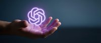 Hand holding glowing purple neon AI symbol representing artificial intelligence technology, machine learning, and digital innovation for tech business concepts.