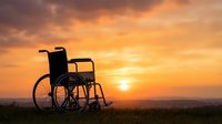 Empty wheelchair silhouetted against golden sunset sky, symbolizing hope, recovery, and resilience in healthcare and wellness contexts.