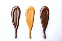 Dripping chocolate and caramel sauce drops isolated on white background. Liquid sweet toppings for dessert decoration and food design elements.