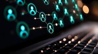 Glowing turquoise network of connected user icons floating above computer keyboard, representing social media connections and digital communication technology.