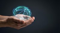 Human hands holding glowing digital brain hologram with neural network connections on dark background for technology and artificial intelligence concepts.