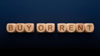 Buy or rent choice displayed on wooden blocks against dark background, representing real estate decision, property investment options, and housing market selection.