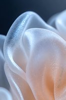 Ethereal abstract macro of flowing white curves with sparkling glitter texture and soft peach glow against dark background, creating dreamy artistic composition.