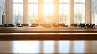 Empty wooden church pews in sunlit sanctuary with large windows, creating peaceful spiritual atmosphere for worship, prayer, or meditation.