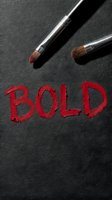 Two makeup brushes with red pigment on dark textured surface spelling bold text, representing cosmetics, beauty artistry, and makeup application for editorial and design projects.
