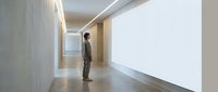 Modern minimalist interior with businessman in suit standing in contemporary office hallway with clean lines and neutral tones for corporate design.