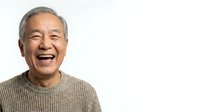 Senior Asian man with gray hair wearing beige knit sweater, smiling warmly at camera against white background. Suitable for healthcare, wellness, lifestyle and senior living concepts.