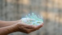 Mature male hand holding glowing holographic cityscape with digital buildings and map overlay, representing urban development, smart city technology, and real estate investment concepts.